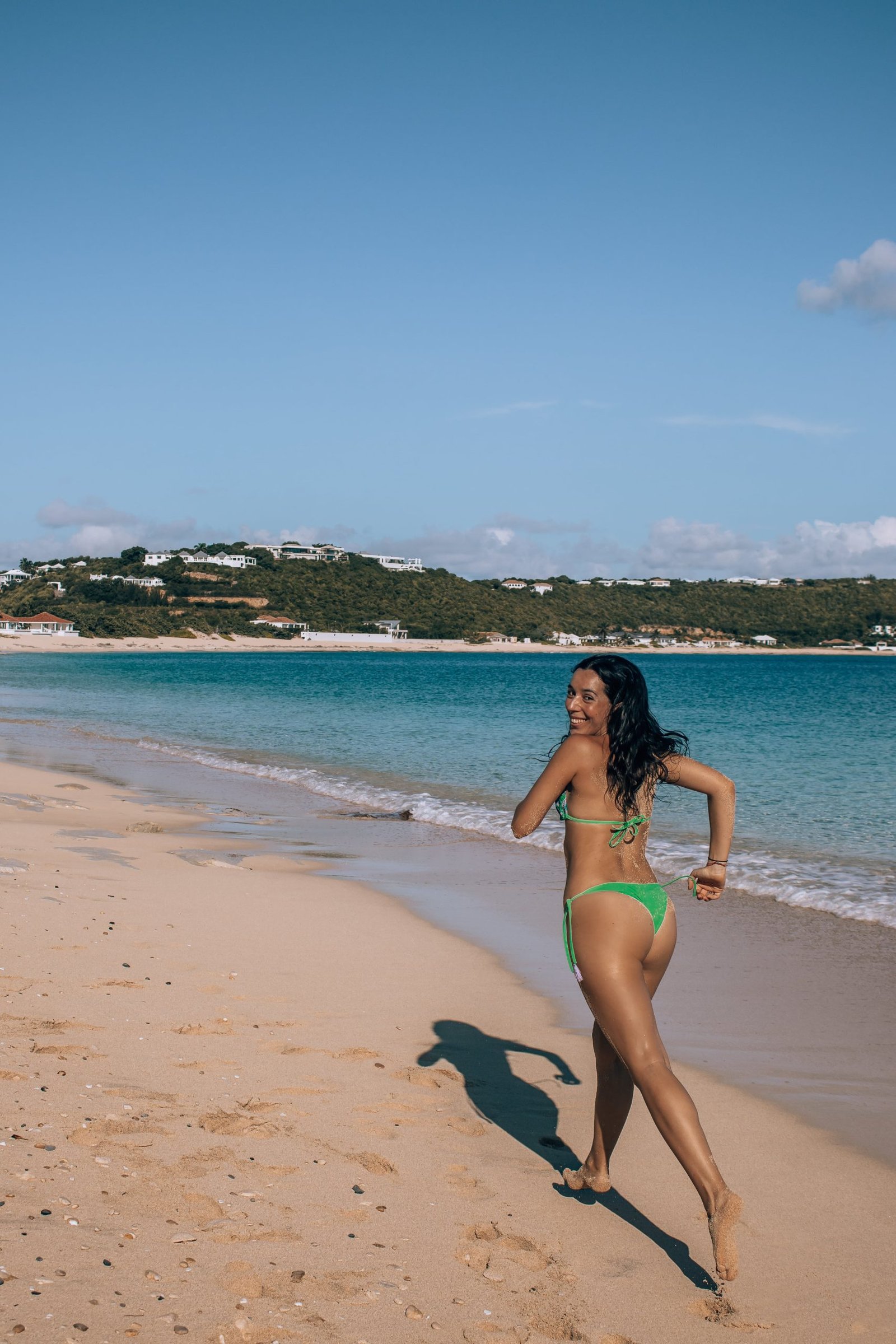 Woman in bikini running on Baie Rouge beach, in Saint-Martin.